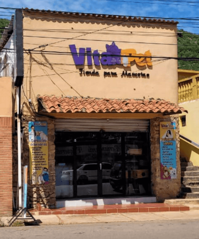 Fachada de VitaPet Tienda para Mascotas con letrero grande, techo de tejas y puertas acristaladas.